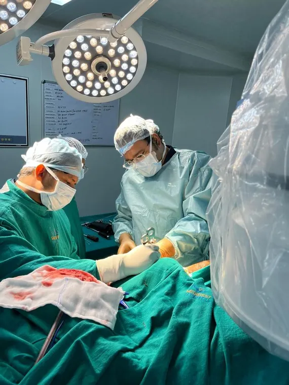 Dr. Kumar Vishal holding an orthopaedic implant plate during trauma surgery